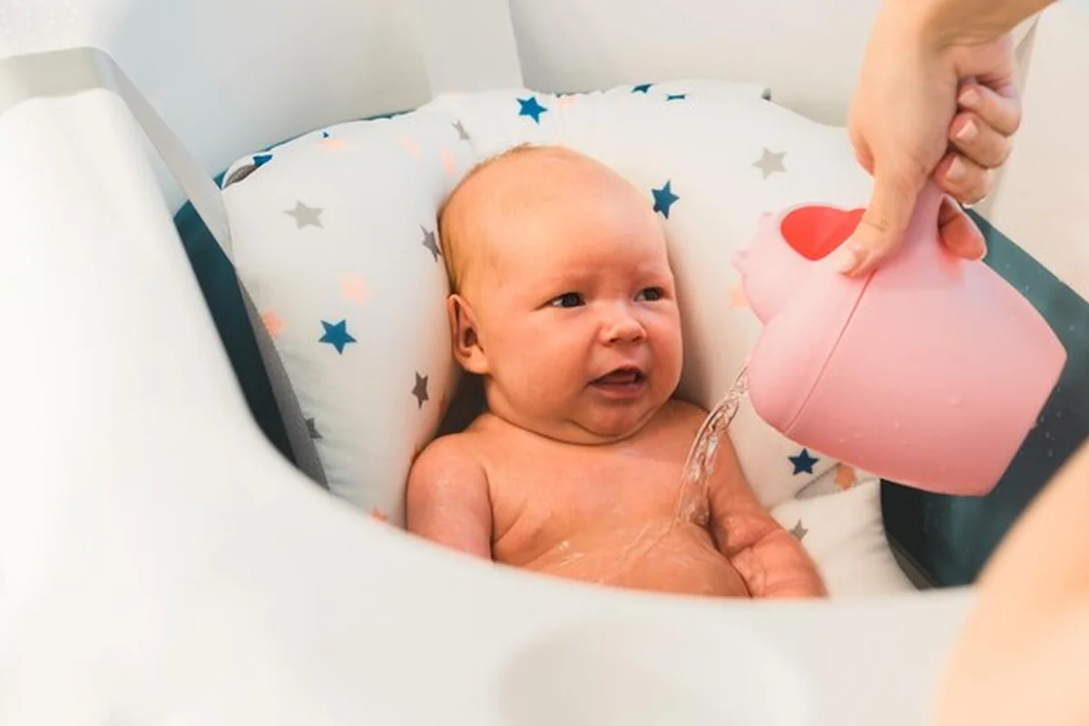 Noworodek płacze podczas kąpieli. Nieszczęśliwe dziecko podczas higieny