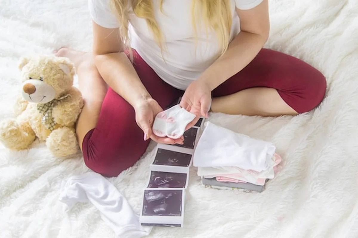 Kobieta w ciąży trzyma migawkę USG