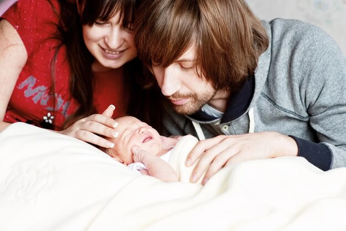 Rodzice patrzący na płaczące dziecko w domu