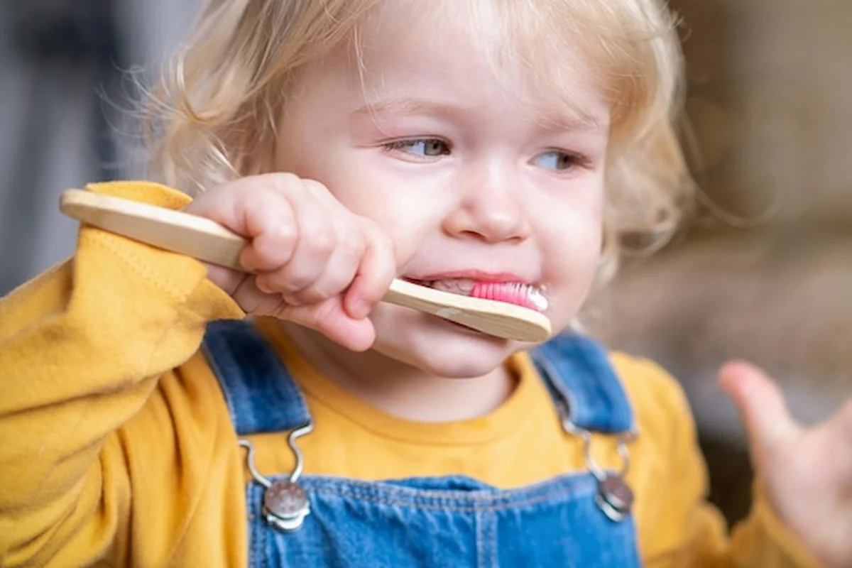 Małe dziecko myje zęby ekologiczną szczoteczką