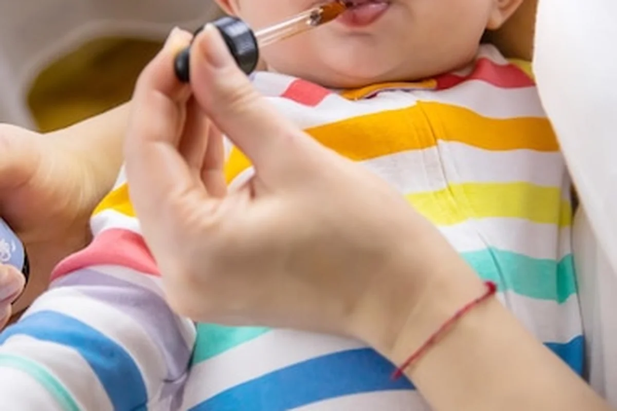 Matka podaje dziecku lek na kolkę