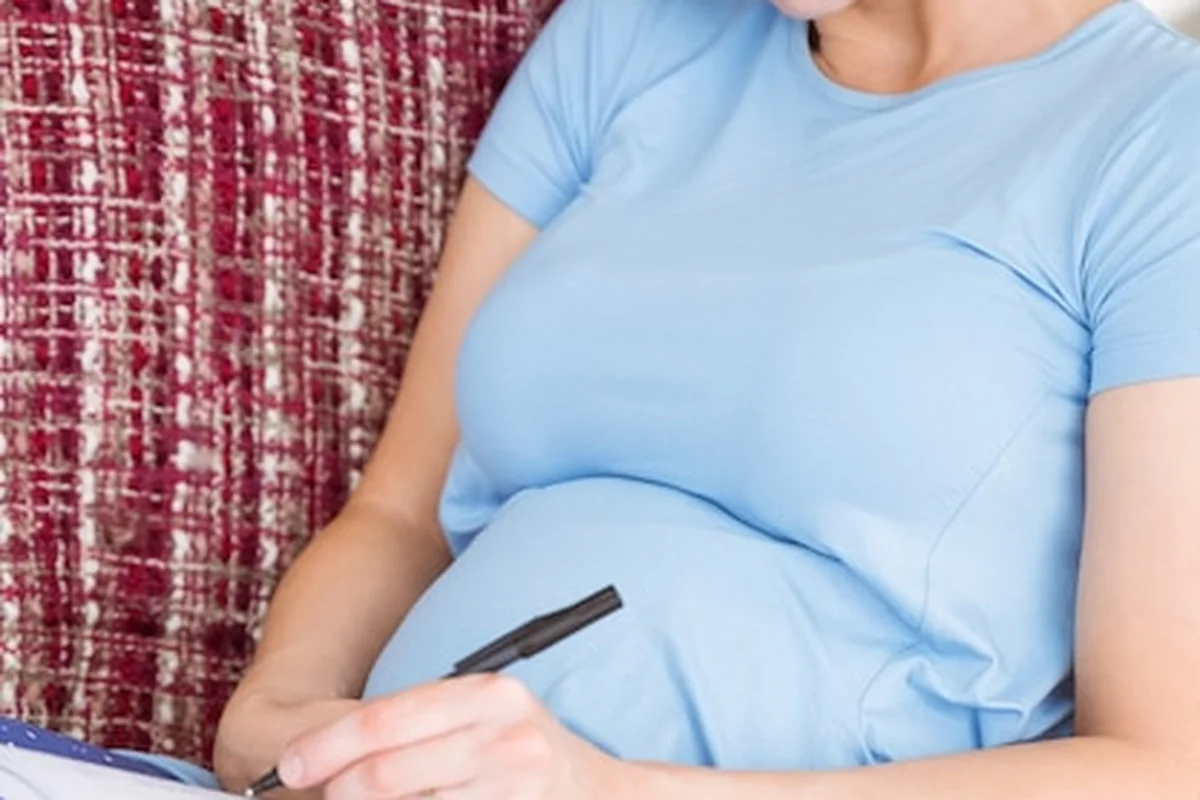 Kobieta w ciąży wpisująca nazwiska dziecka