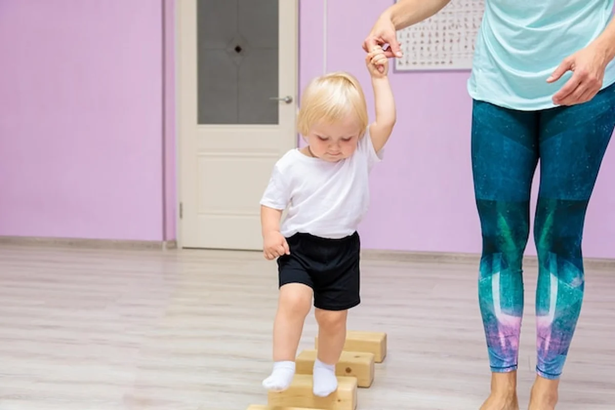 Mama i dziecko na siłowni wykonują ćwiczenia rozwojowe