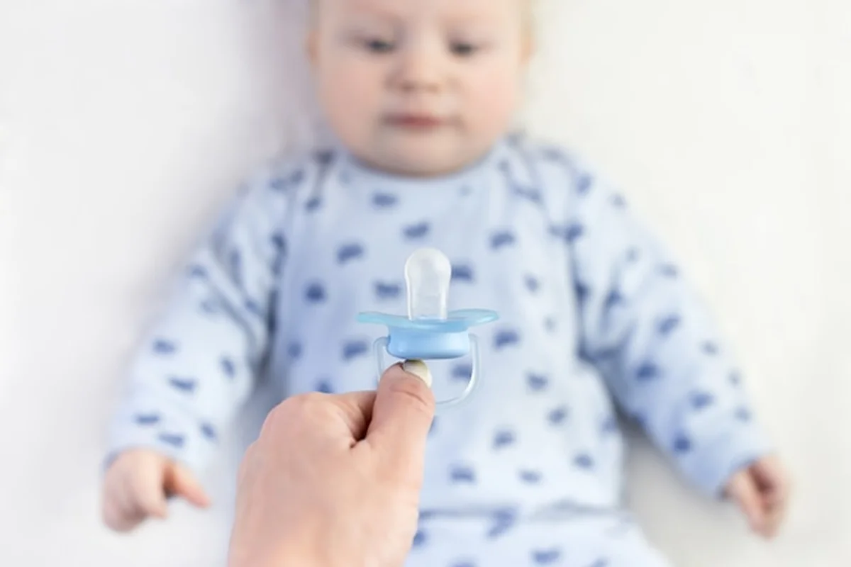 Mama podaje smoczek dziecku