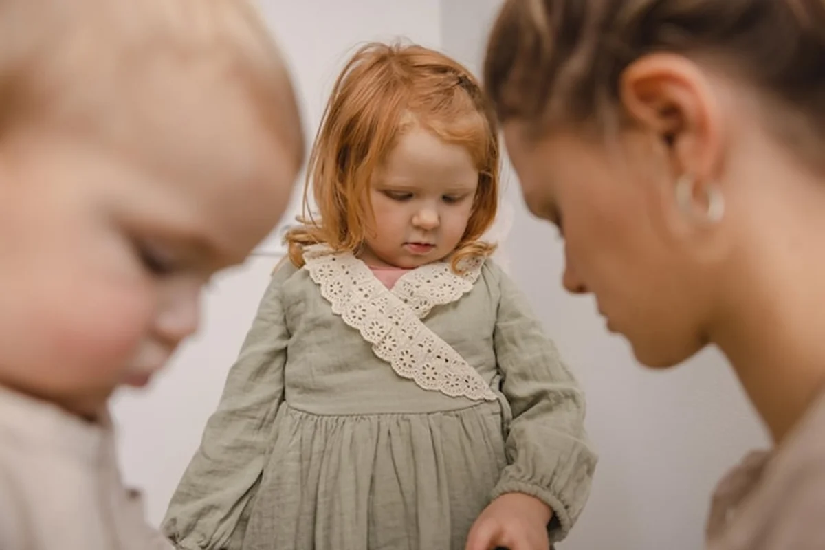 Dwójka dzieci i niania w pomieszczeniu