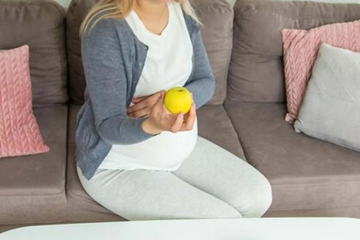 Kobieta w ciąży je słodkie jabłko