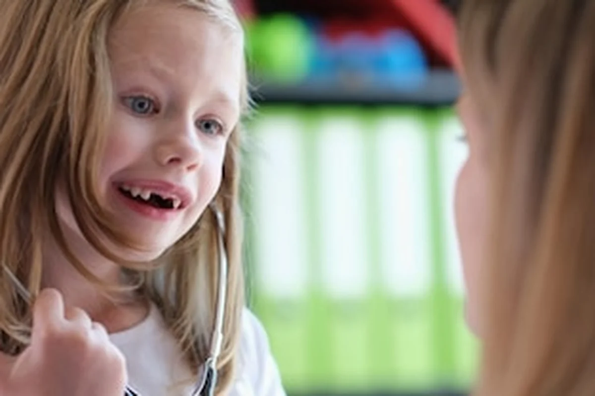 Lekarz rodzinny bawi się z małą pacjentką w klinice medycznej