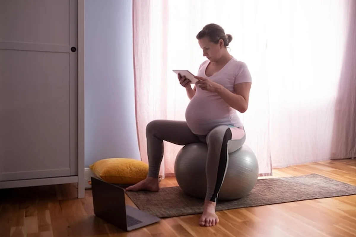 Młoda kobieta w ciąży ćwiczy jogę w domu