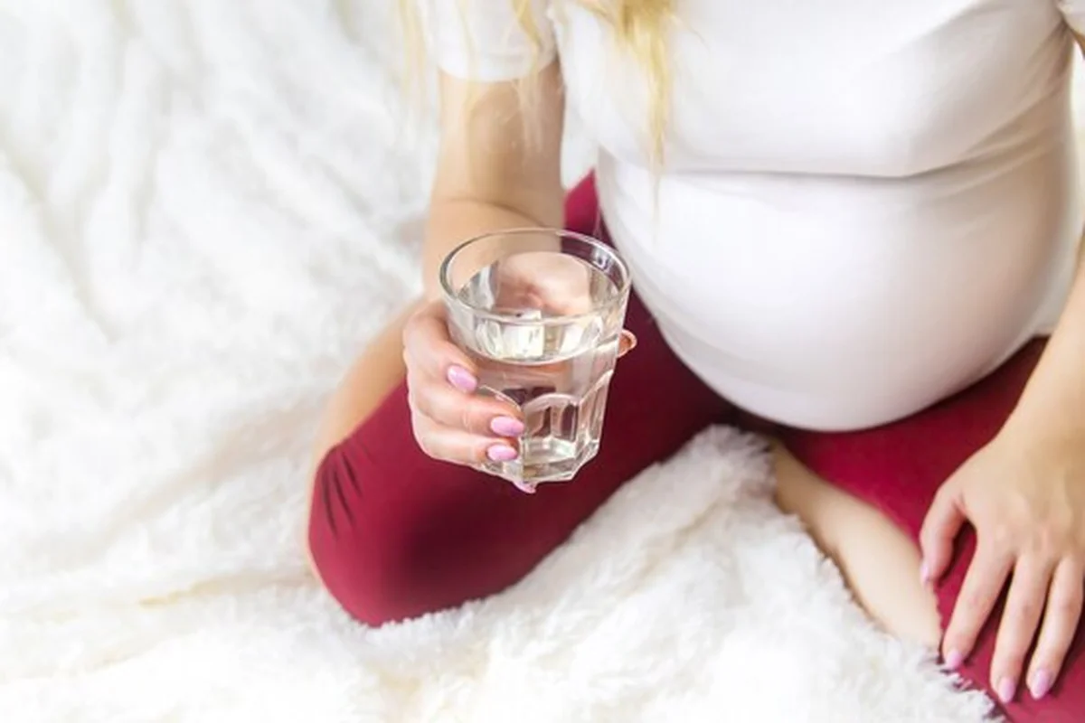 Kobieta w ciąży pije wodę
