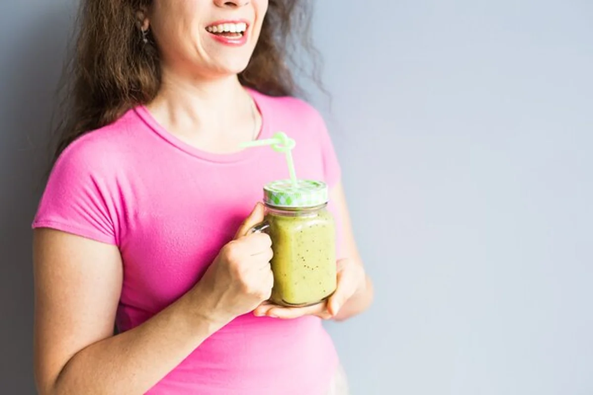 Zdrowy zielony koktajl ze szparagami w kobiecej dłoni