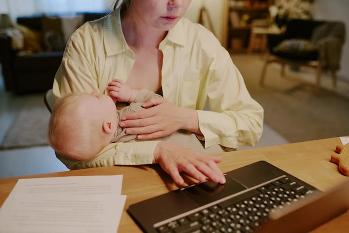 Matka karmiąca piersią dziecko podczas pracy