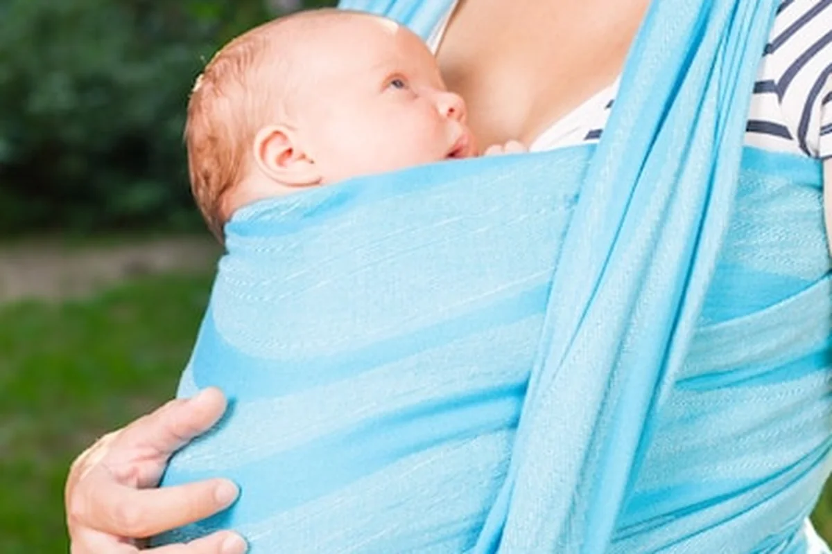 Matka niosąca nowo narodzone dziecko na świeżym powietrzu